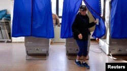FILE - A voter leaves a polling booth during the U.S. presidential election in Philadelphia, Pennsylvania, Nov. 8, 2016.