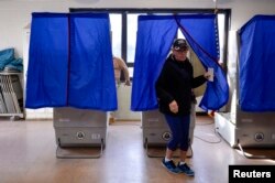 FILE - A voter leaves a polling booth during the U.S. presidential election in Philadelphia, Pennsylvania, Nov. 8, 2016.