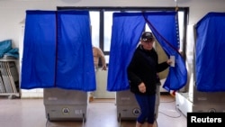 FILE - A voter leaves a polling booth during the U.S. presidential election in Philadelphia, Pennsylvania, Nov. 8, 2016.