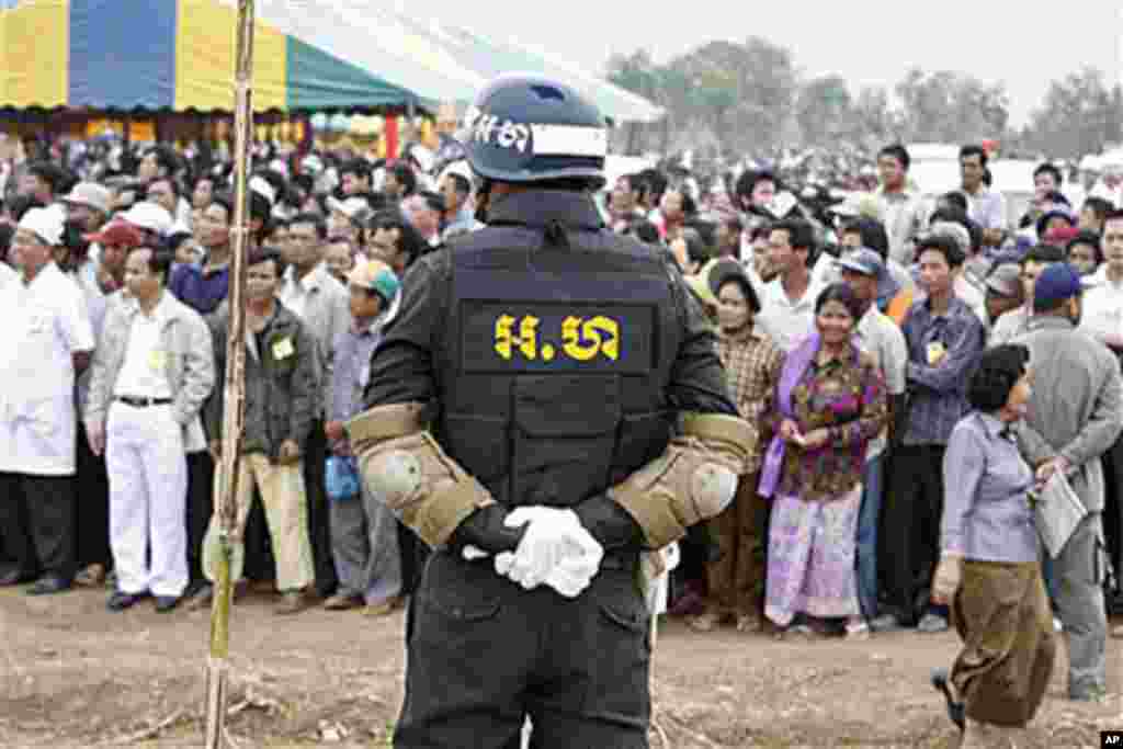 A Cambodian military policeman stands watch during the ground breaking ceremony of a Chinese funded road at Koun Damrey village, Banteay Meanchey province, about 15 kilometers (9 miles) east of Cambodia's border with Thailand, February 15, 2011