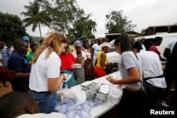FILE - A nongovernmental organization distributes meals to victims of August mudslide at the internally displaced persons camp in Regent, Sierra Leone, Aug. 19, 2017.