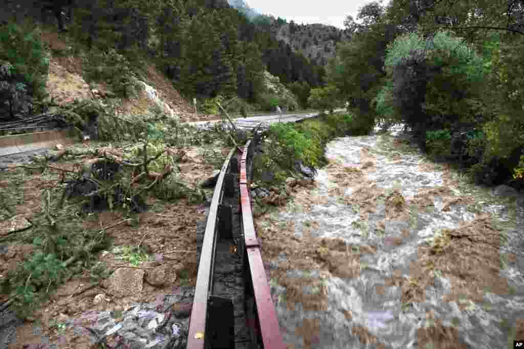 Boulder Creek flows at high speed next to a road closed off by debris from days of rain and flooding, at the base of Boulder Canyon, Colorado, Sept. 13, 2013. 