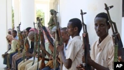FILE- Armed men from the al-Shabab militant group are paraded at the presidential palace in Mogadishu, Somalia, after defecting from the al-Qaida-linked group to join government forces, Oct. 13, 2009.