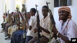 FILE- Armed men from the al-Shabab militant group are paraded at the presidential palace in Mogadishu, Somalia, after defecting from the al-Qaida-linked group to join government forces, Oct. 13, 2009.