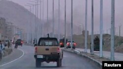 Security vehicles rush towards smoke rising in the distance, as an area near the Kabul airport comes under attack, in this still image taken from a Reuters TV video in Kabul, July 17, 2014.