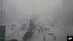 Motorcycles and vehicles are driven on a road in Peshawar, Pakistan, Nov. 5, 2017. Smog has enveloped much of Pakistan and neighboring India, causing highway accidents and respiratory problems, and forcing many residents to stay home, officials said. 