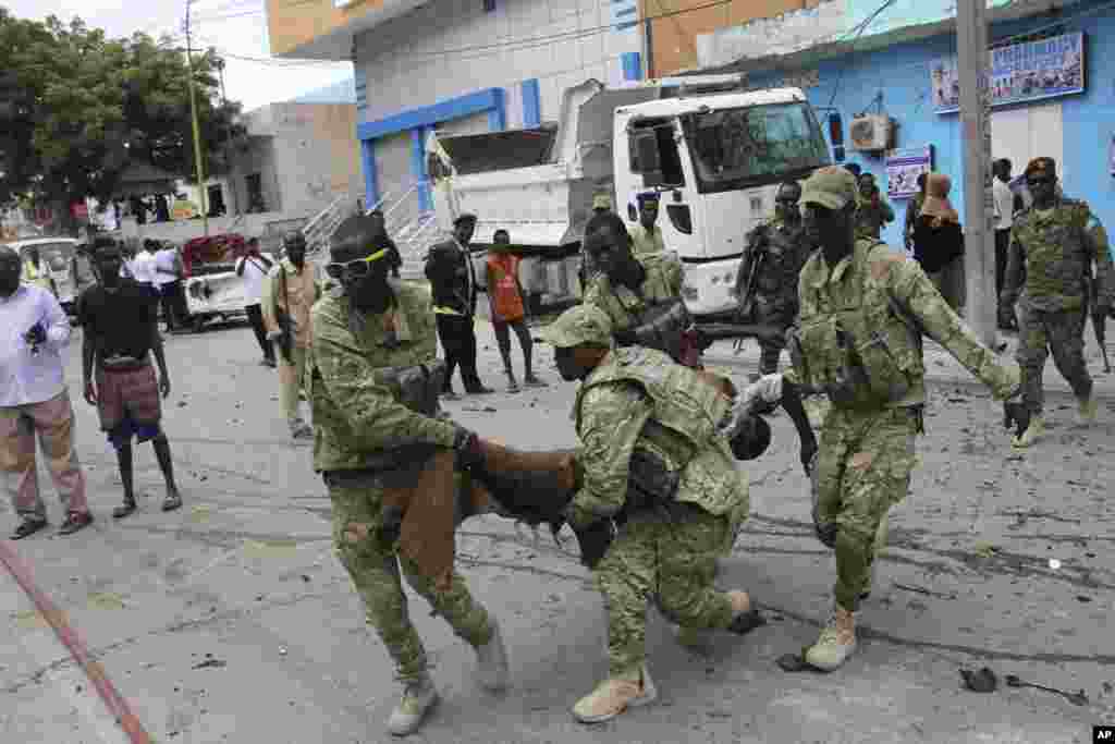 Les soldats somaliens transportent un cadavre qui a été tué dans l&#39;attaque à Mogadiscio, en Somalie, le 30 juillet 2017.