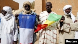 People hold Malian and French flags during the reopening ceremony of Mahamane Fondogoumo elementary school in the town center of Timbuktu February 1, 2013. REUTERS/Benoit Tessier (MALI - Tags: POLITICS SOCIETY EDUCATION) - RTR3D7ZT