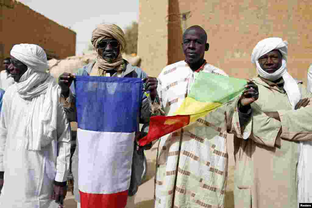 People hold Malian and French flags during the reopening ceremony of Mahamane Fondogoumo elementary school in the town center of Timbuktu, February 1, 2013.&nbsp;