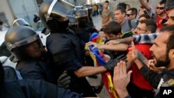 Mossos d'Esquadra police officers scuffle with protesters during a demonstration supporting Catalonia's independence referendum in Terrassa, Spain, Sept. 19, 2017.