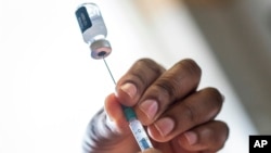 A nurse fills a syringe with COVID-19 vaccine at Soweto's Baragwanath hospital, South Africa, Dec. 13, 2021.