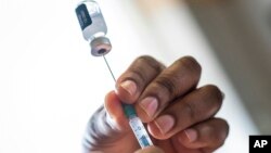 A nurse fills a syringe with COVID-19 vaccine at Soweto's Baragwanath hospital, South Africa, Dec. 13, 2021.