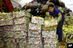 FILE - A worker at a can recycling center stacks pressed cans in Rio de Janeiro, Brazil, Dec. 7, 2000. (AP Photo/Douglas Engle)