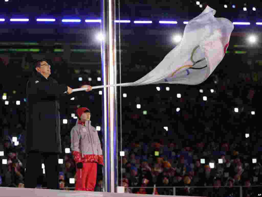 Chen Jining, mayor of Beijing, waves the Olympic flag during the closing ceremony of the 2018 Winter Olympics in Pyeongchang, Feb. 25, 2018.