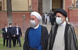 Le président iranien sortant Hassan Rouhani (à gauche) avec le nouveau président Ebrahim Raisi lors de la cérémonie de passation des pouvoirs à Téhéran, le 3 août 2021.