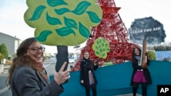 NGO representatives shout “clean the air, plant a tree,” near a reproduction of the Eiffel Tower at the U.N. Climate Change Conference in Le Bourget, north of Paris, Dec. 5, 2015.