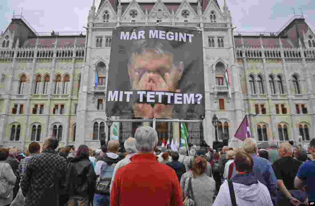 Para pendukung oposisi membawa poster PM Hungaria Viktor Orban dalam aksi unjuk rasa di Budapest atas kebijakan pemerintah yang anti-migran.