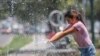 Una niña juega con agua mientras Argentina enfrenta una ola de calor histórica con temperaturas que superan los 40 grados centígrados (104 °F) y obliga a los residentes a buscar refugio a la sombra en Salta, Argentina, el 13 de enero de 2022.