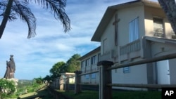 FILE - The residence and office of the Archbishop of Agana is seen in Hagatna, Guam, Nov. 7, 2018. Guam's Catholic Church has filed for bankruptcy, a move that will allow the archdiocese to avoid trial in dozens of child sexual abuse lawsuits and enter settlement negotiations.