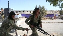 Turkish-backed Syrian fighters take part in a battle in Syria's northeastern town of Ras al-Ain in the Hasakeh province along the Turkish border as Turkey and its allies continue their assault on Kurdish-held border towns in northeastern Syria.