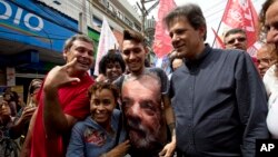 Workers' Party candidate for vice-president Fernando Haddad, 2nd from right, walks with a supporter who wears a shirt with a photo of former President Luiz Inacio Lula da Silva during a campaign rally in Rio de Janeiro, Brazil, Aug. 28, 2018. 