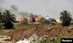 Smoke rises from gas storage tanks after a bomb attack against a state-run cooking gas factory in Taji at Baghdad's northern outskirts, Iraq, May 15, 2016.