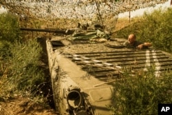 FILE - A Ukrainian government soldier looks toward pro-Russia rebel positions near Avdiivka, outside Donetsk, eastern Ukraine, Aug. 24, 2015.