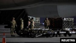 Ukrainian service members unload a shipment of military aid delivered as part of the United States of America's security assistance to Ukraine, at the Boryspil International Airport outside Kyiv, Ukraine, Jan. 25, 2022. 