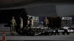 Ukrainian service members unload a shipment of military aid delivered as part of the United States of America's security assistance to Ukraine, at the Boryspil International Airport outside Kyiv, Ukraine, Jan. 25, 2022. 