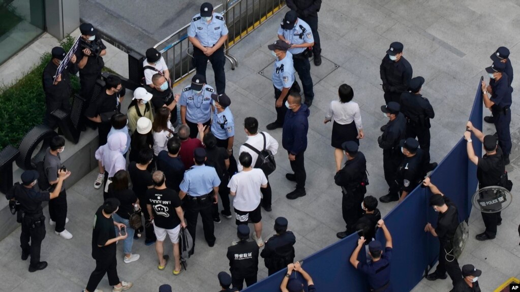 一些投资者2021年9月下旬到深圳恒大总部抗议时被警察和保安阻拦。(photo:VOA)