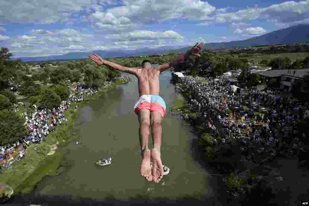 A diver jumps from the 22-meter-high bridge &quot;Ura e Shenjte&quot; near the town of Gjakova, Kosovo, as a sign of protest after police canceled the 70th traditional annual High Diving competition at the bridge due to spectators failing to keep social distancing rules.