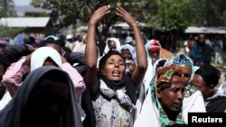 FILE - Women mourn during the funeral ceremony of Dinka Chala, a primary school teacher who family members said was shot dead by military forces during a recent demonstration, in Holonkomi town, in Oromia region of Ethiopia, Dec. 17, 2015.