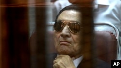 FILE-- In this Saturday, April 26, 2014 file photo, ousted Egyptian President Hosni Mubarak attends a hearing in his retrial over charges of failing to stop killings of protesters during the 2011 uprising that led to his downfall.