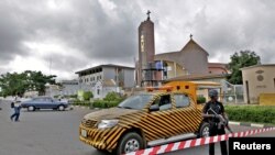 A police officer stands guard outside the Holy Trinity Catholic Church in Nigeria's capital Abuja, June 24, 2012, after tit-for-tat attacks between Muslims and Christians in Kaduna, sparked by suicide bombings blamed on Islamist sect Boko Haram.