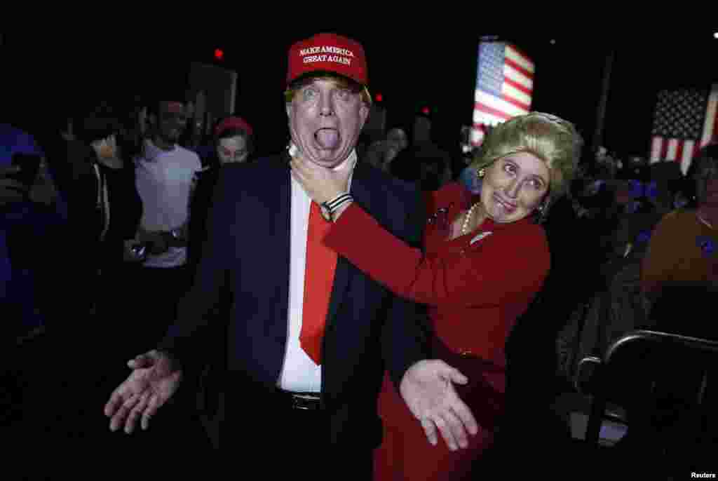 Supporters of Democratic presidential candidate Hillary Clinton, who came to her rally in costume as Republican presidential candidate Donald Trump (L) and as Mrs. Clinton (R), clown around as they attend her Super Tuesday night party in Miami, Florida, March 1, 2016.