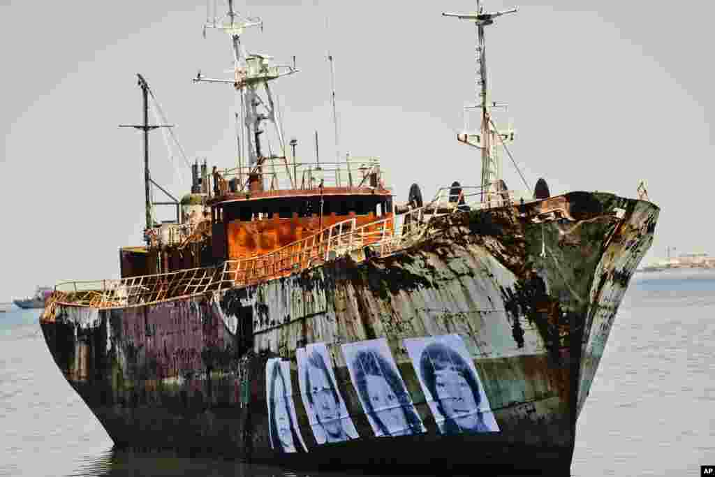 Images of Uruguayans disappeared during the 1973-1985 military dictatorship are displayed on the hull of an abandoned ship aground in the bay of Montevideo, Dec. 21, 2016.