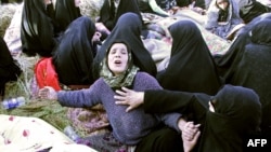 Iranians mourn over the covered bodies of loved ones in the village Baje-Baj, near the town of Varzaqan, who were killed in twin earthquakes that hit northwestern Iran, August 12, 2012.