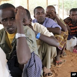 Newly arrived Somali refugees queue for relief food at the Dadaab refugee camp, near the Kenya-Somalia, July 23, 2011