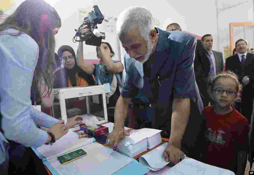 Algeria National Liberation Front leader Abdelaziz Belkhadem registers his thumbprint as he prepares to cast his ballot in Algiers.