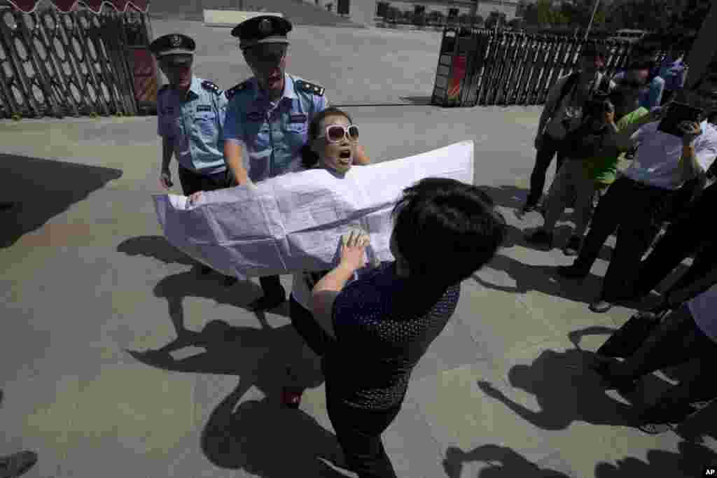 2013年8月21日，一名中国妇女（中戴墨镜者）在济南中级人民法院外抗议。除了少数薄熙来支持者到场抗议外，还有个别公民利用薄案开审引起媒体关注的机会申诉自己的冤情。
