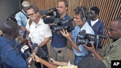 Members of the media surround war double-amputee Alhaji Jusu Jarka outside the Special Court for Sierra Leone, after a live broadcast of the verdict by a UN-backed court in the Hague convicting former Liberian president Charles Taylor of war crimes, in ca