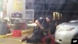 视频截图显示，奥尔顿•斯特林2016年7月5日在路易斯安那州巴吞鲁日的一家便利店外受到两名警察拘留
