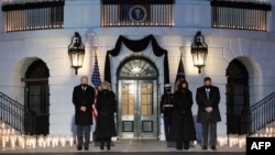 US President Joe Biden, First Lady Jill Biden, US Vice President Kamala Harris and her husband, Doug Emhoff, hold a moment of silence during a candelight ceremony in honor of those who lost their lives to Coronavirus on the South Lawn of the White House.(Photo by SAUL LOEB / AFP)