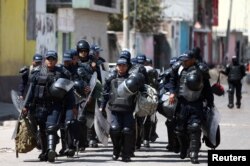 Police officers patrol a street after a blockade set by members of the Santa Rosa de Lima Cartel to repel security forces during an anti-fuel theft operation in Santa Rosa de Lima, in Guanajuato state, Mexico, March 6, 2019.