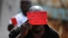 FILE - A Congolese opposition party supporter displays a red card against President Joseph Kabila in Kinshasa, Democratic Republic of the Congo, Dec. 19, 2016.