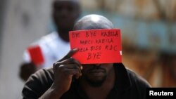 FILE - A Congolese opposition party supporter displays a red card against President Joseph Kabila in Kinshasa, Democratic Republic of the Congo, Dec. 19, 2016.