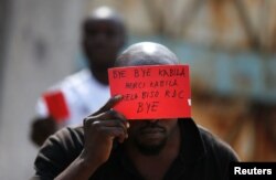 A Congolese opposition party supporter displays a red card against President Joseph Kabila in Kinshasa, Democratic Republic of Congo Dec. 19, 2016.