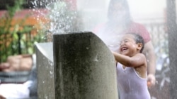 A child plays in a sprinkler last month in New York City during a heat wave