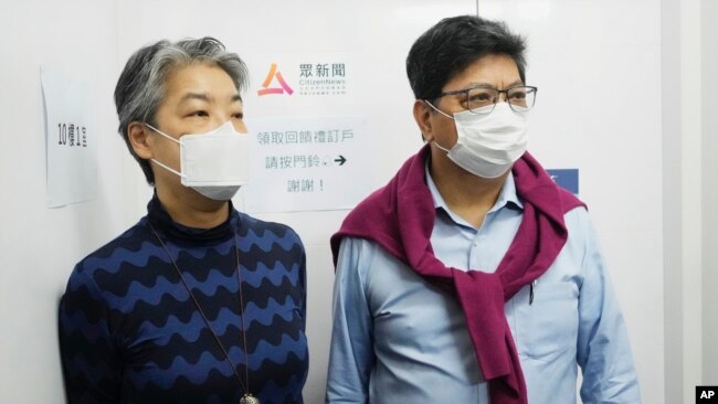 Chris Yeung, right, founder and chief writer, and Daisy Li, chief editor of Citizen News, stand outside their office before a news conference in Hong Kong, Monday, Jan. 3, 2022. (AP Photo/Vincent Yu)