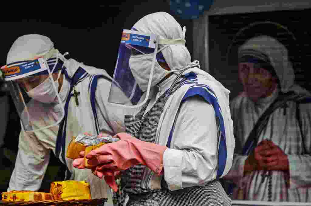 Nuns of the Missionaries of Charity, the order founded by Saint Teresa, wear masks and face shields as precaution against the coronavirus as they distribute food to poor and homeless people in Kolkata, India, on Mother Teresa&#39;s 110th birth anniversary.